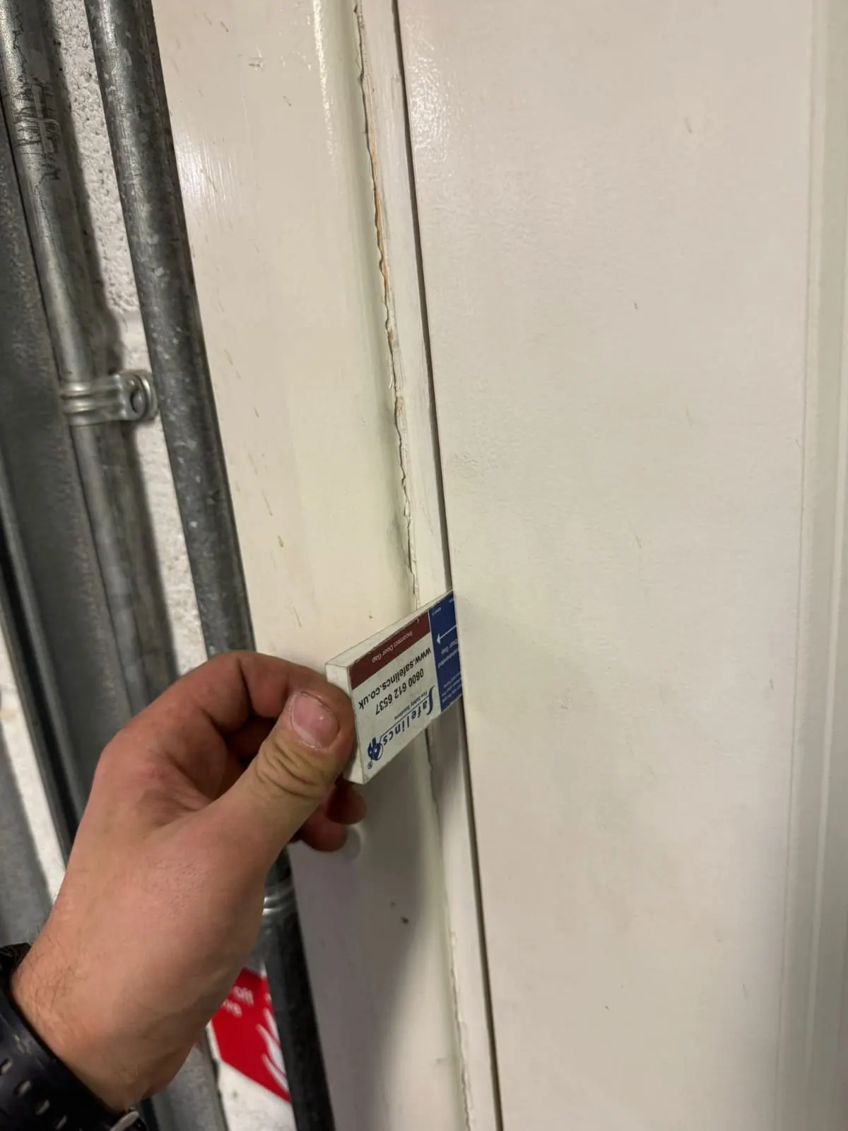 Inspector checking the certification label on the edge of a fire door