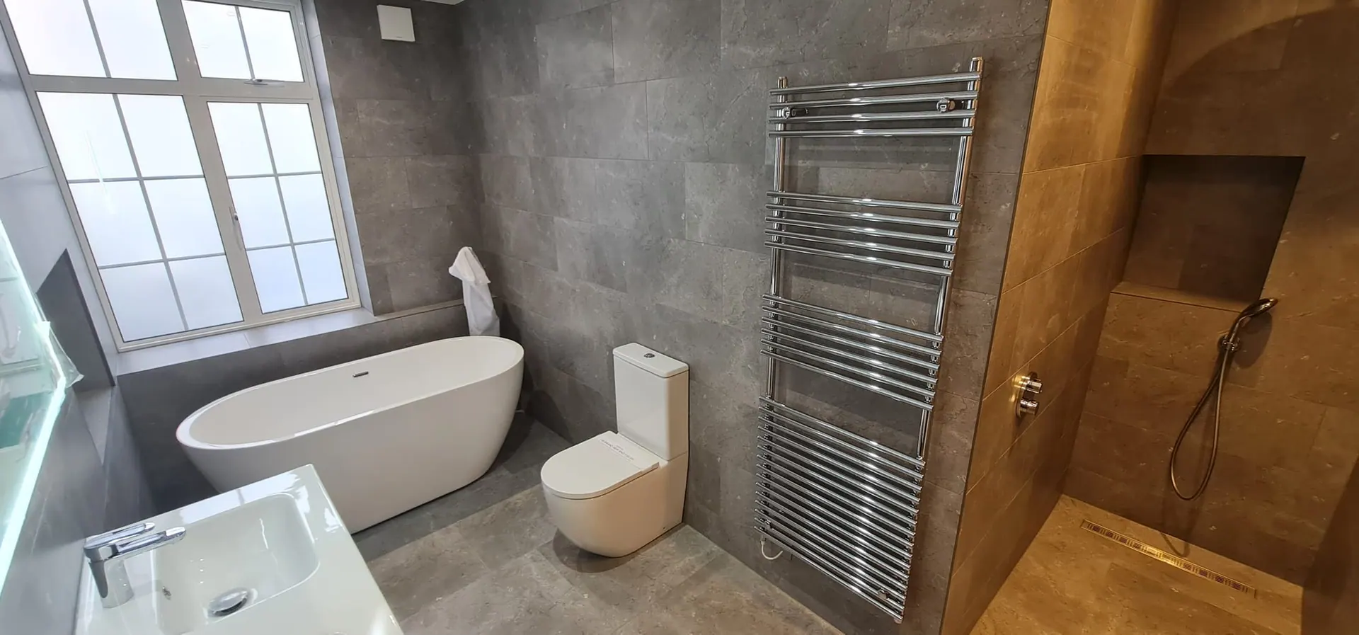 Tiled bathroom with a freestanding bath, heated towel rail and walk-in shower