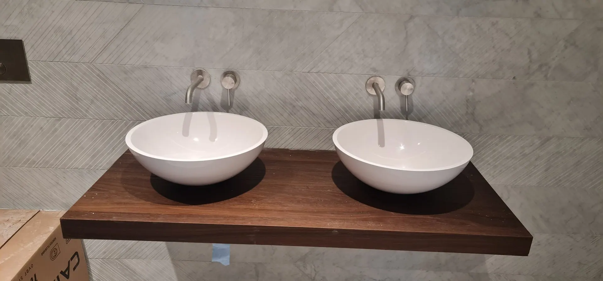 Twin countertop basins on a floating walnut shelf