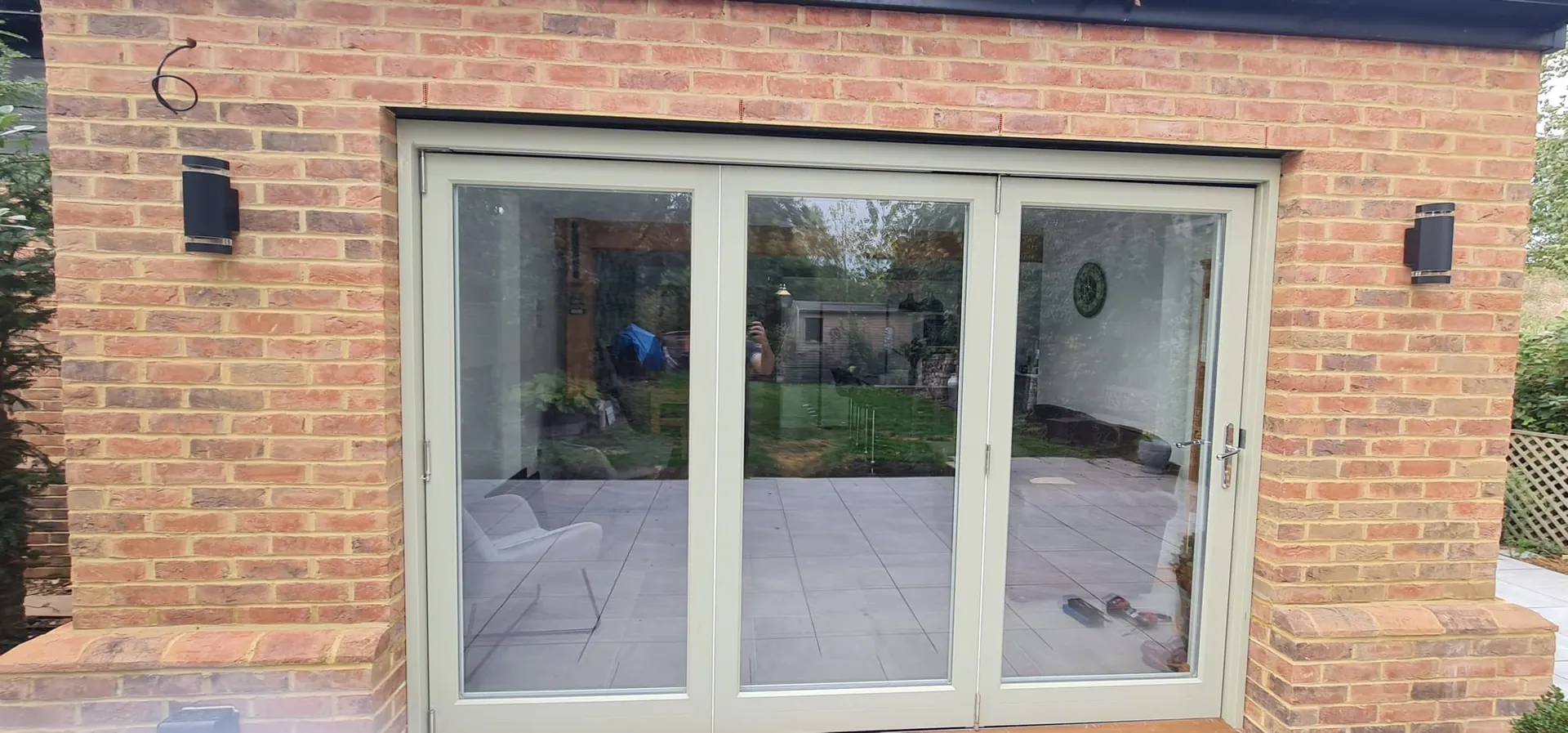 Sage French doors with side lights in a brick extension