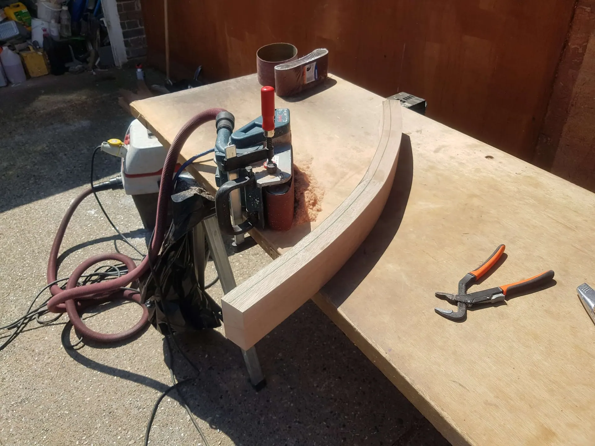 Curved timber handrail section being shaped on a bench